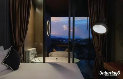 a bedroom with a bed and a large window at Saturays condo One Bedroom Suite 178 in Ban Saiyuan (1)