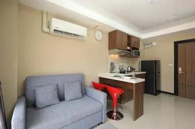 a living room with a couch and a kitchen at 1bdr apartment NaiHarn Beach condo by Capital Pro in Phuket Town