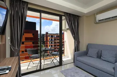 a living room with a couch and a balcony at 1bdr apartment NaiHarn Beach condo by Capital Pro in Phuket Town