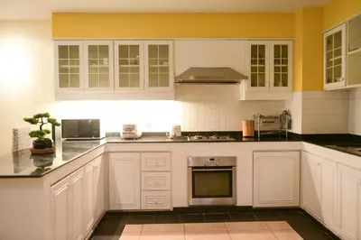 a kitchen with white cabinets and black counter tops at Shimmer Three-Bedroom Villa with large garden and two swimming pools in Rawai Beach