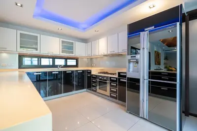 a kitchen with white cabinets and a blue ceiling at The Thara Villa Surin Beach in Surin Beach