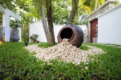 a pile of garlic on the grass next to a vase at The Thara Villa Surin Beach in Surin Beach