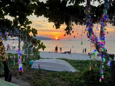a boat on the beach with a sunset in the background at Patong Vacation Rentals - Located in the Heart of Patong, Studio Apartments walking distance to the beach, King Bed, Kitchen, Private Bathroom, Seating Area, 65