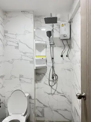 a bathroom with a toilet and a white marble wall at Patong Vacation Rentals - Located in the Heart of Patong, Studio Apartments walking distance to the beach, King Bed, Kitchen, Private Bathroom, Seating Area, 65