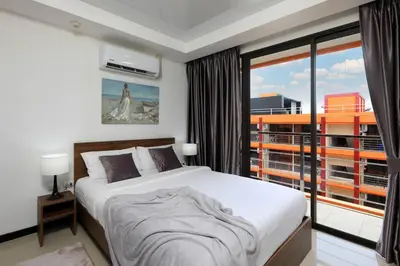 a bedroom with a bed and a large window at New Condo NaiHarn Beach by Capital Pro in Phuket Town