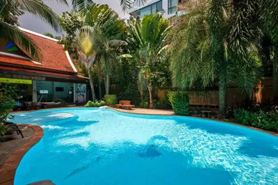 a large blue swimming pool with palm trees at New Condo NaiHarn Beach by Capital Pro in Phuket Town