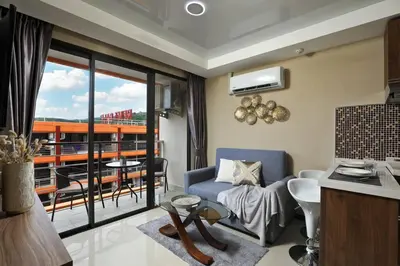 a living room with a couch and a balcony at New Condo NaiHarn Beach by Capital Pro in Phuket Town