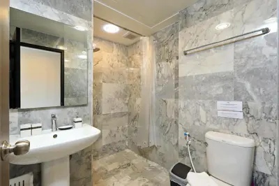a bathroom with a sink and a toilet and a mirror at Naiharn Sea Condo by Capital Pro in Phuket Town
