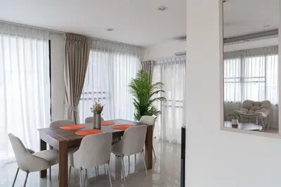 a dining room with a wooden table and chairs at Welcoming 3bdr Townhouse Laguna Park in Ban Phru Champa