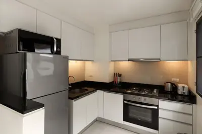a kitchen with white cabinets and stainless steel appliances at Welcoming 3bdr Townhouse Laguna Park in Ban Phru Champa