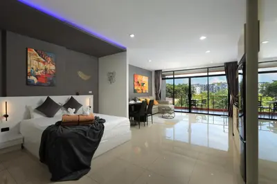 a bedroom with a white bed and a dining room at 1bdr Spacious Studio near NaiHarn Beach by Capital Pro in Phuket Town