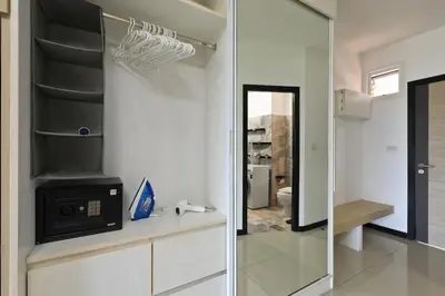 a bathroom with a mirror and a sink and a refrigerator at 1bdr Spacious Studio near NaiHarn Beach by Capital Pro in Phuket Town