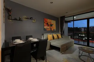 a living room with a couch and a table at 1bdr Spacious Studio near NaiHarn Beach by Capital Pro in Phuket Town