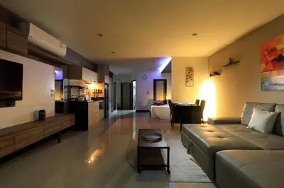 a living room with a couch and a table at 1bdr Pool Access Studio on NaiHarn Beach by Capital Pro in Phuket Town