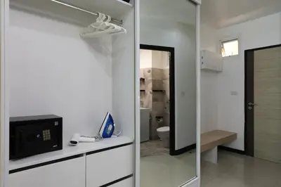 a bathroom with a toilet and a tv and a mirror at 1bdr Pool Access Studio on NaiHarn Beach by Capital Pro in Phuket Town
