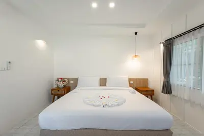 a bedroom with a white bed with a cake on it at Ban Raya Resort and Spa in Ko Racha Yai