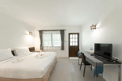 a bedroom with a bed and a desk with a television at Ban Raya Resort and Spa in Ko Racha Yai