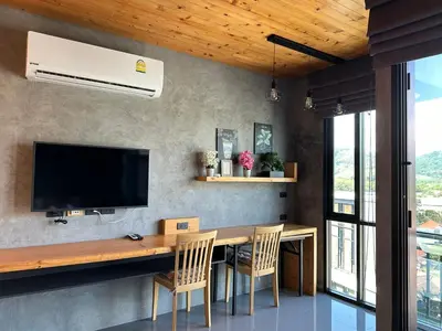a dining room with a table with chairs and a television at 1bdr Apartment Relife Naiharn by Capital Pro in Phuket Town