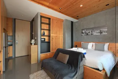 a bedroom with a bed and a chair at 1bdr Apartment ReLife Windy Naiharn by CapitalPro in Phuket Town
