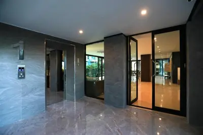 an empty lobby with glass doors and a elevator at 1bdr Apartment ReLife Windy Naiharn by CapitalPro in Phuket Town