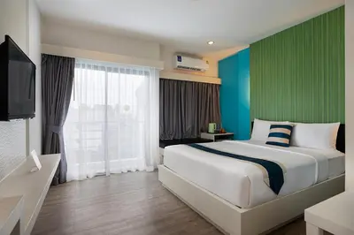 a bedroom with a large bed and a large window at iCheck inn Chill Patong in Patong Beach