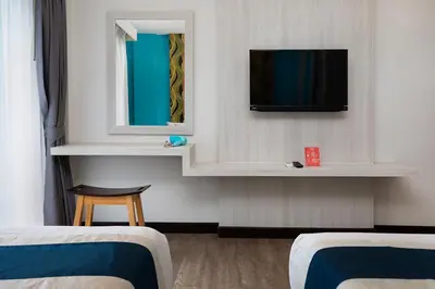 a room with two beds and a tv on a wall at iCheck inn Chill Patong in Patong Beach