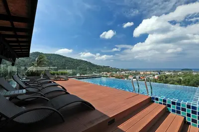 a swimming pool with chairs on a wooden deck at 1bdr Apartment on the Kata Beach SPL-101 by Capital Pro in Phuket Town