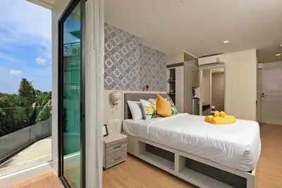 a bedroom with a large bed and a balcony at 1bdr Apartment on the Kata Beach SPL-101 by Capital Pro in Phuket Town