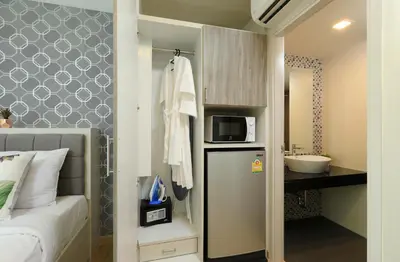 a small bathroom with a bed and a microwave at 1bdr Apartment on the Kata Beach SPL-101 by Capital Pro in Phuket Town