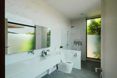 a bathroom with a toilet and a sink and a mirror at Villa Mimosa 2, Splendid 3 Bedroom Master Ensuite in Phuket Town