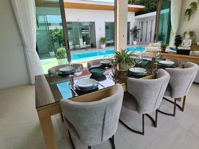 a dining room with a table and chairs and a pool at Villa Mimosa 2, Splendid 3 Bedroom Master Ensuite in Phuket Town