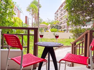 a table with two chairs and two glasses of wine at Best Location Patong Near Jungceylon + Pool Access in Patong Beach