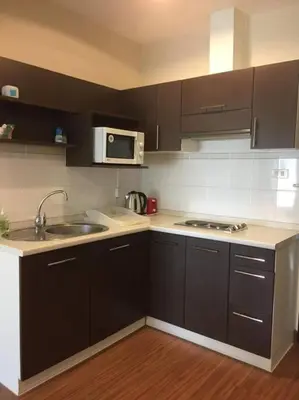 a kitchen with black cabinets and a sink and a microwave at Best Location Patong Near Jungceylon + Pool Access in Patong Beach