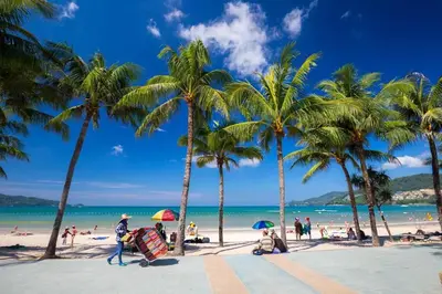 a group of people on a beach with palm trees at Best Location Patong Near Jungceylon + Pool Access in Patong Beach