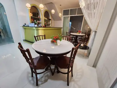 a dining room with a white table and chairs at PPhouse Boutique House Phuket Town in Ban Bang Khu