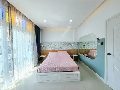 a bedroom with a pink bed and a mirror at PPhouse Boutique House Phuket Town in Ban Bang Khu