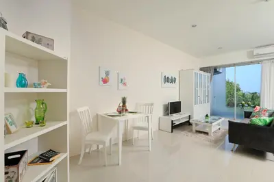 a white living room with a table and chairs at 1bdr Apartment with bath in Chic Condo By Capital Pro in Phuket Town