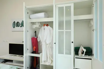 a closet with a white door and a television at 1bdr Apartment with bath in Chic Condo By Capital Pro in Phuket Town