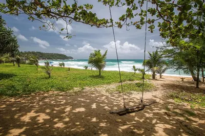 a swing on a beach with the ocean in the background at 1bdr Apartment with bath in Chic Condo By Capital Pro in Phuket Town