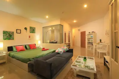 a bedroom with a bed and a couch and a table at 1bdr Apartment with bath in Chic Condo By Capital Pro in Phuket Town