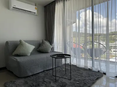 a living room with a couch and a large window at New apartment Rawai Beach 310 by Capital Pro in Phuket Town