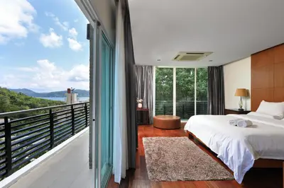 a bedroom with a bed and a balcony with a view at Dolphin Villa in Patong Beach