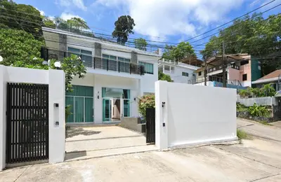 a white house with two gates in front of it at Dolphin Villa in Patong Beach