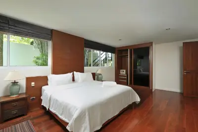 a bedroom with a large white bed and a large window at Dolphin Villa in Patong Beach