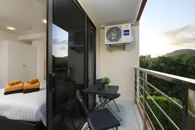a bedroom with a balcony with a bed and a table at New apartment Rawai Beach 218 by Capital Pro in Phuket Town