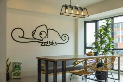 a dining room table with a monkey stencil on the wall at Chamemon Bed Phuket Town in Phuket Town