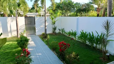 a garden with a white fence and some flowers at Jasmine Village in Rawai Beach