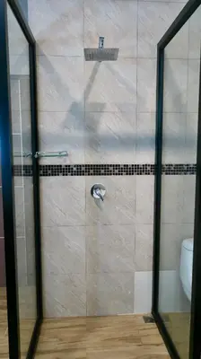 a shower with a glass door in a bathroom at Jasmine Village in Rawai Beach