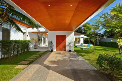 a house with a red door and a yard at 4bdr Modern Villa Signature by CapitalPro in Phuket Town