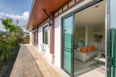 a glass extension of a house with a couch at 3bdr VIP Villa Rawai with private pool in Phuket Town